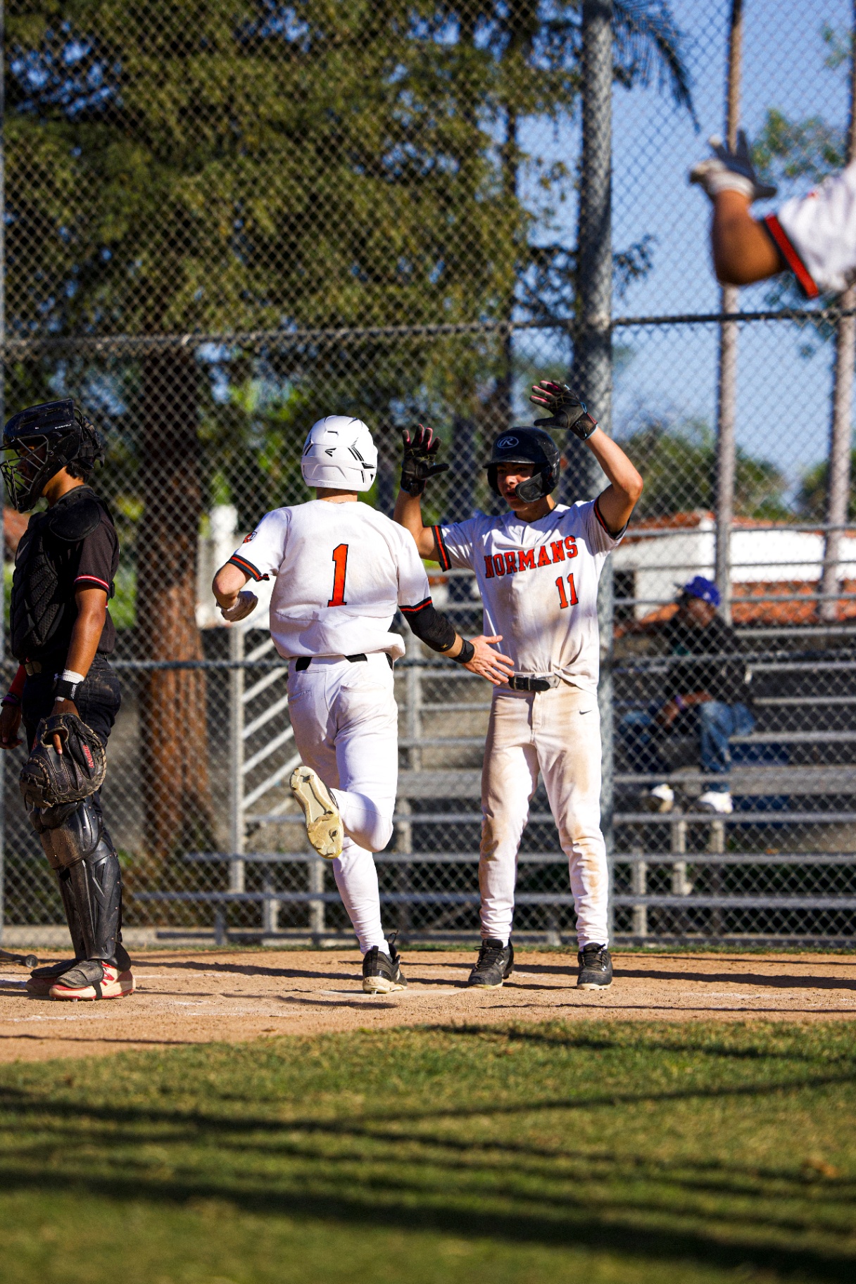 Fed Ramirez waiting at home plate to high-five a teammate after a run